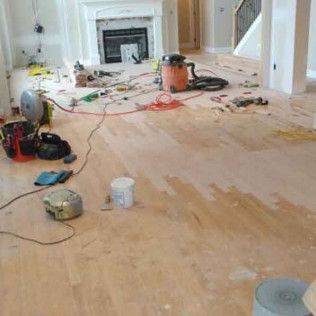 Living Room With Hardwood Floors Being Installed and a Vacuum Cleaner on the Floor