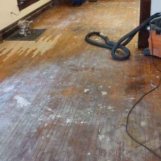 A Vacuum Cleaner is Sitting on a Wooden Floor in a Room