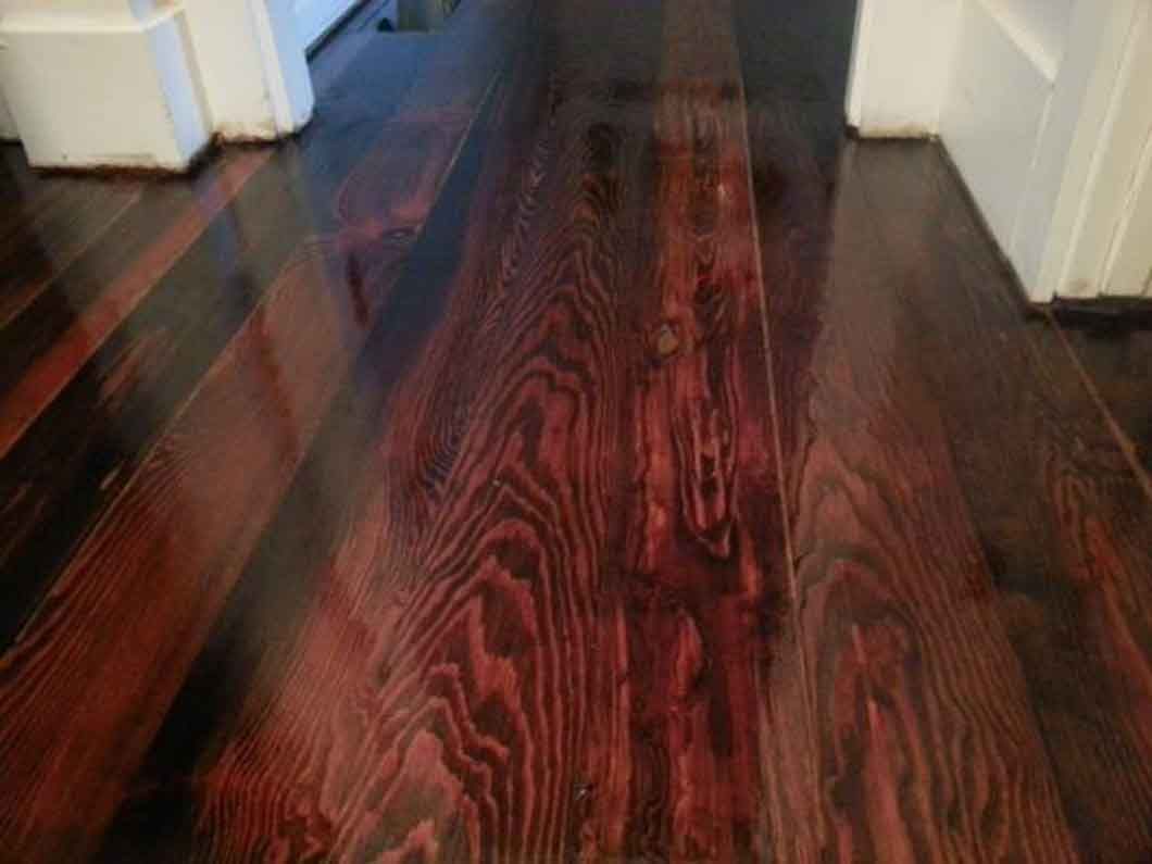 A close up of a wooden floor in a hallway.