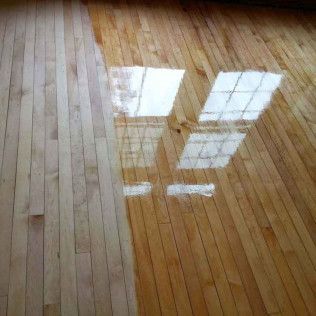 A Wooden Floor With a Reflection of a Window in It