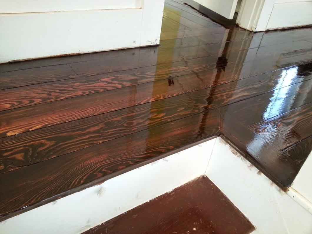 A close up of a wooden floor in a room with stairs.