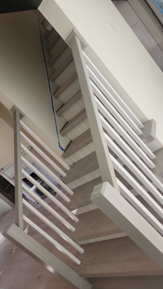 A close up of a staircase with a white railing.