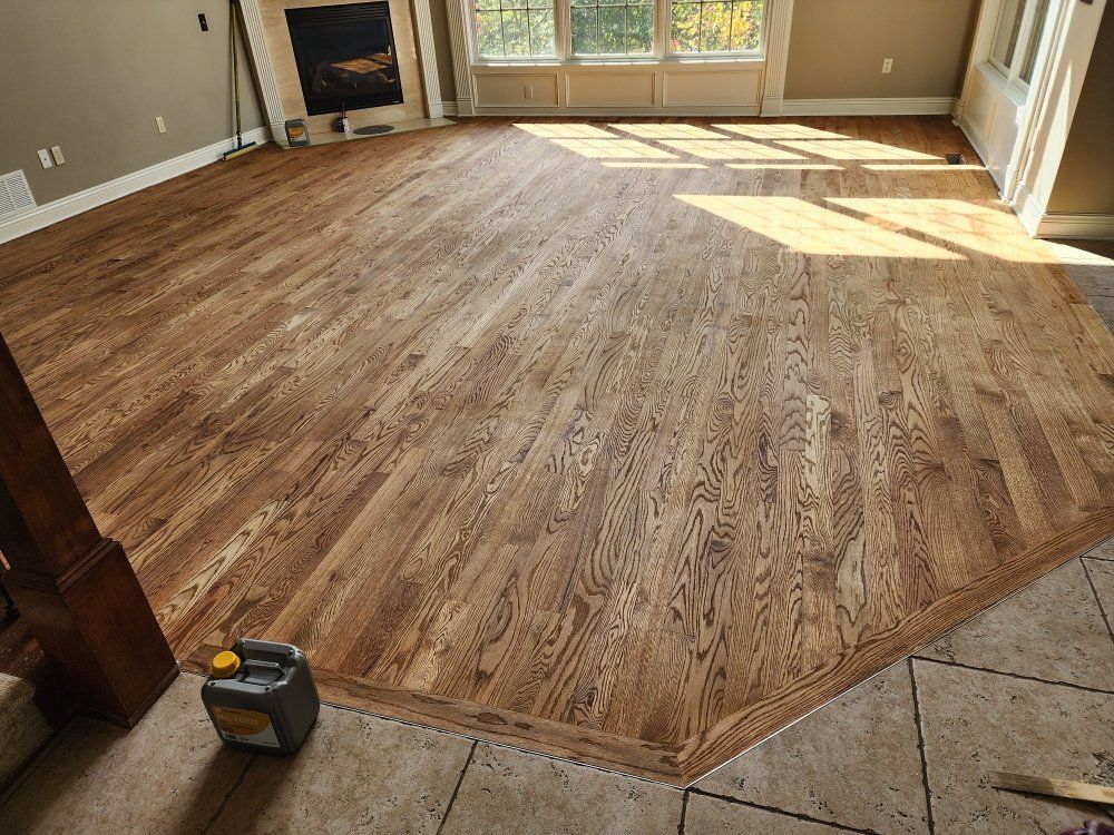 A living room with a wooden floor and a fireplace.