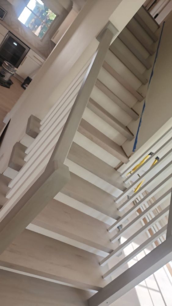 A staircase with a white railing is being built in a house.