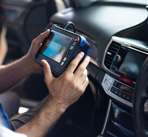 A man is using a tablet in a car