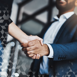 A man in a suit shakes hands with a woman