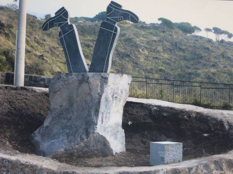 opera in pietra lavica con gambe e piedi capovolti