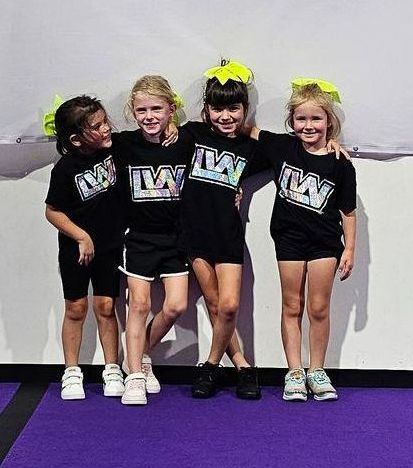 A group of young girls wearing black shirts with the letter w on them