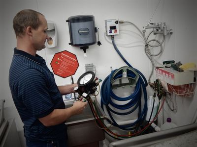 Inspection & Certifications — Inspector Holding Back-flow Meter in Austin, TX