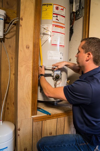 Plumbing — Man Repairing a Water Heater in Austin, TX