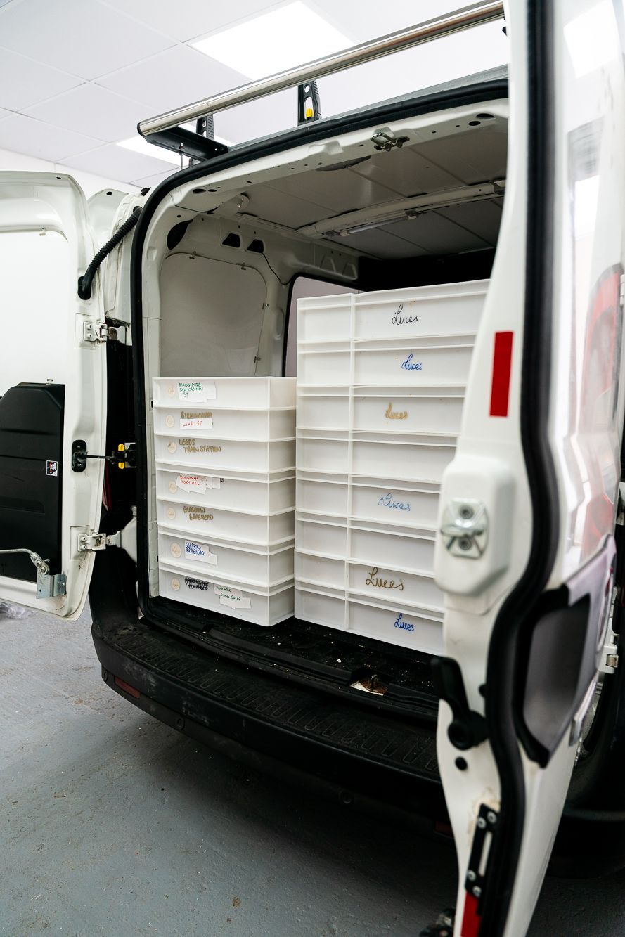 The back of a white van with boxes in it.