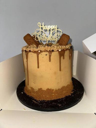 A cake with a happy birthday topper is sitting in a box.