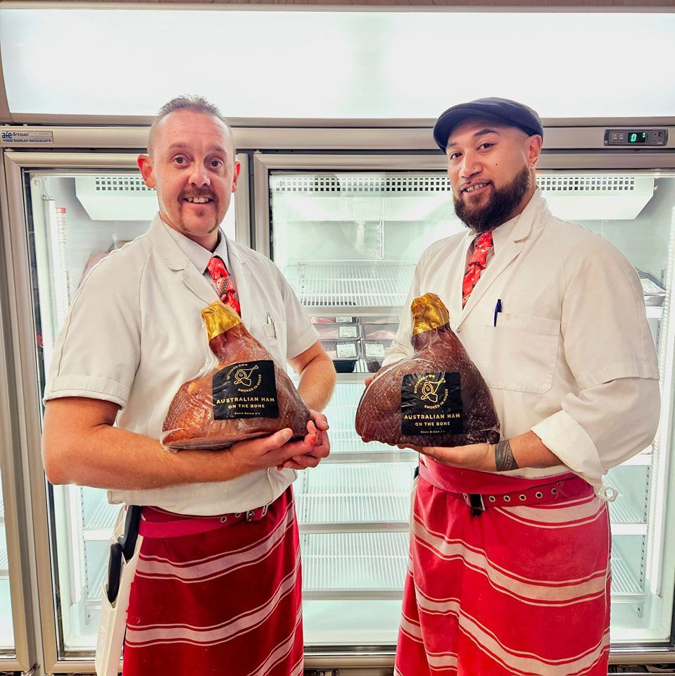 Two Men Are Standing Next To Each Other Holding Turkeys In Front Of A Refrigerator — Elite Meats in Holt, ACT