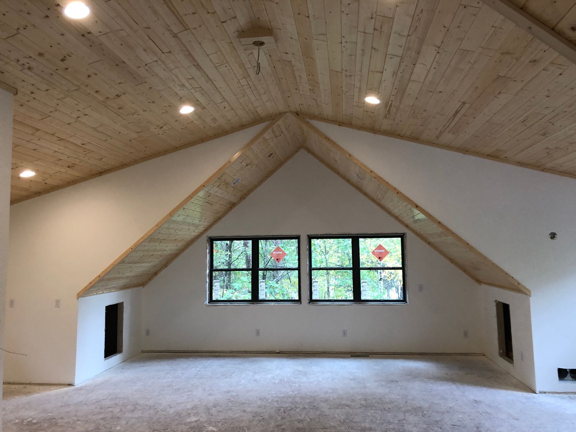 A room with a vaulted ceiling and a lot of windows