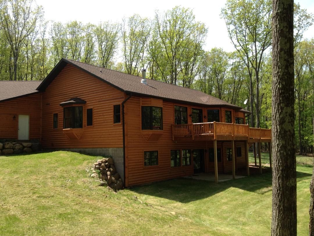 A screened in porch with a wooden deck and a ceiling fan