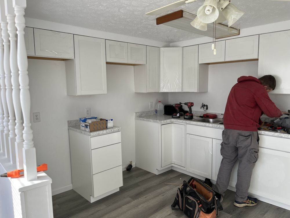 A worker installing a cabinets in kitchen