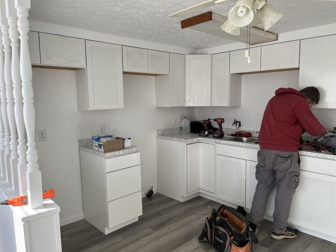 A worker installing a cabinets in kitchen