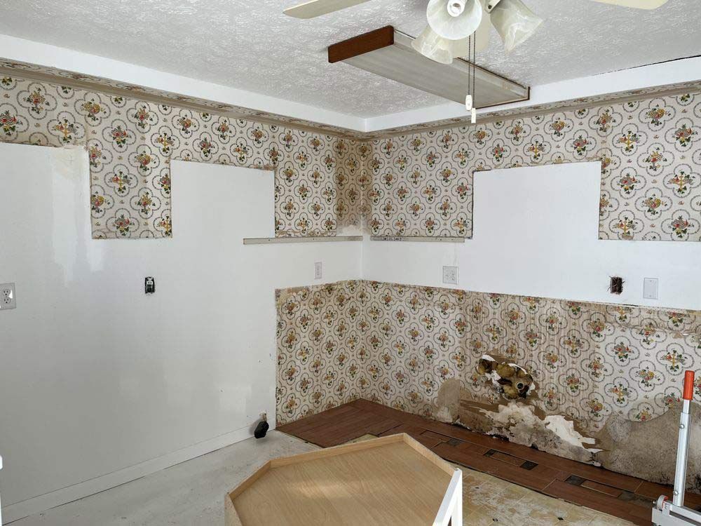 Interior room with patterned wallpaper partially removed
