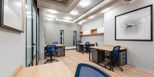 A room with a lot of desks and chairs in it.