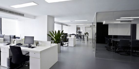 A large empty office with a lot of desks and chairs.
