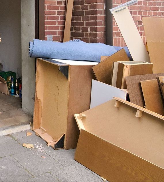 A pile of cardboard boxes and a blue blanket on top of a wooden box