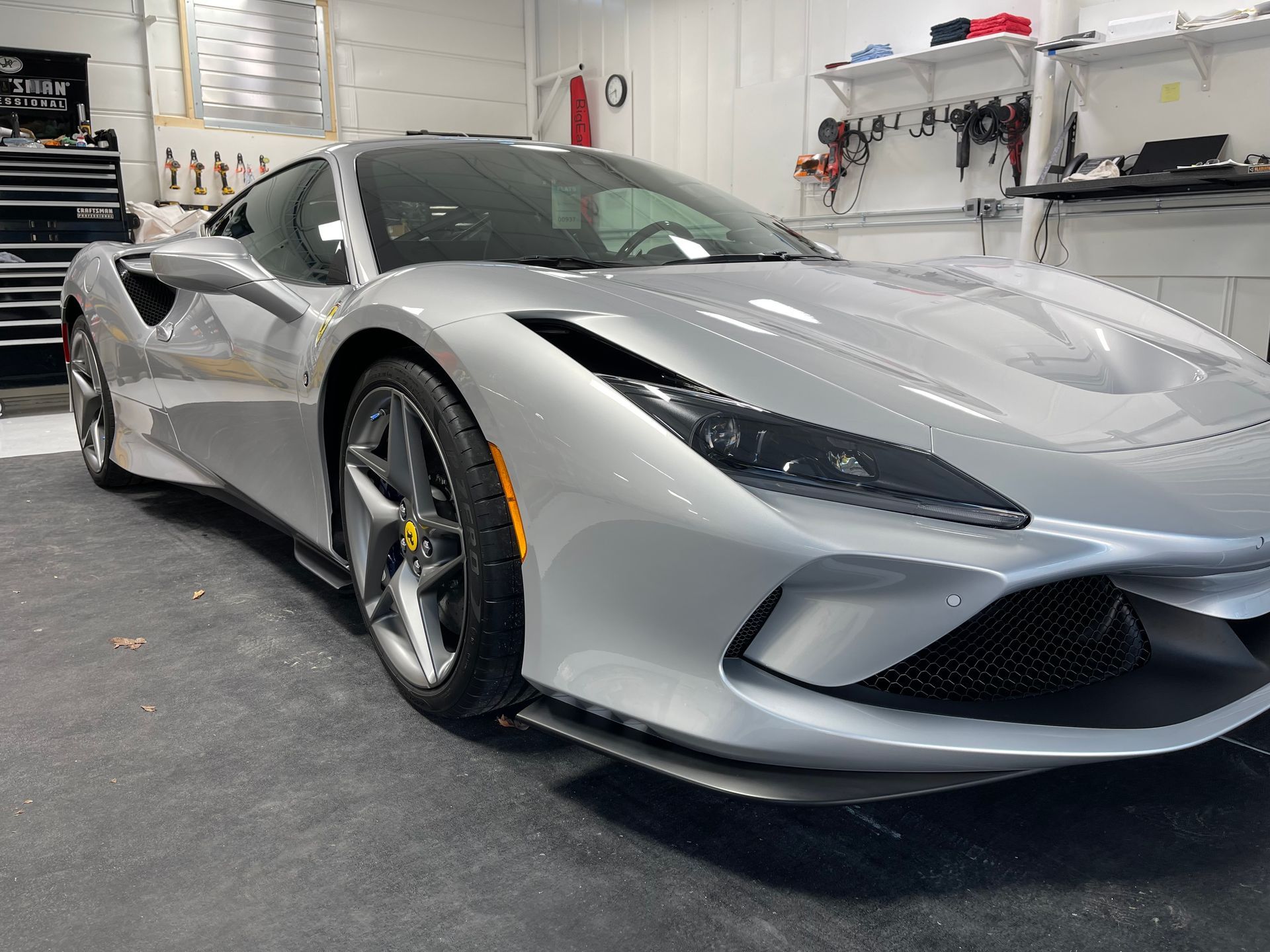 A silver sports car is parked in a garage.