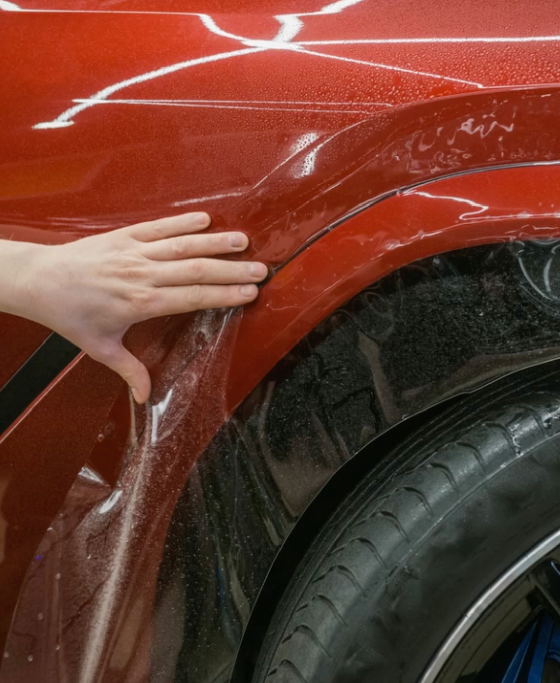 Paint protection film installation on red car