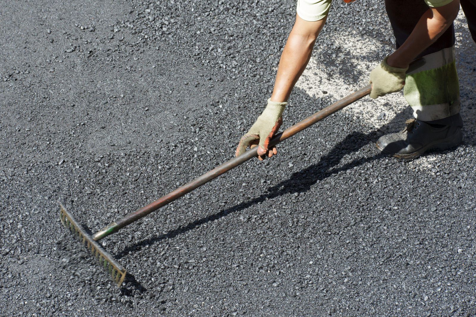 A person is raking the ground with a rake.