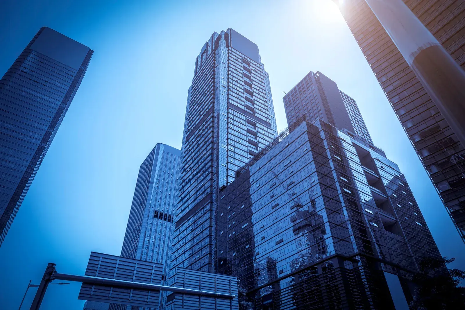 Two yellow steamrollers compacting fresh asphalt on a road under construction.