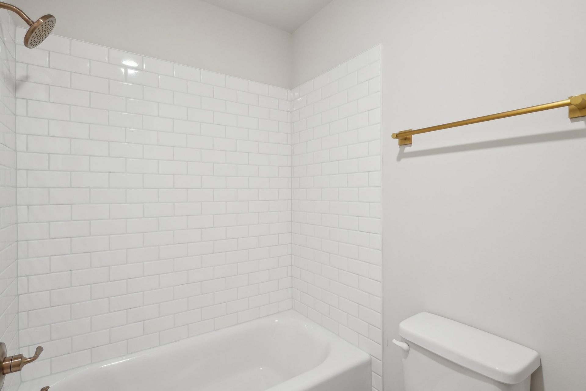 A bathroom with a bathtub , toilet and shower.