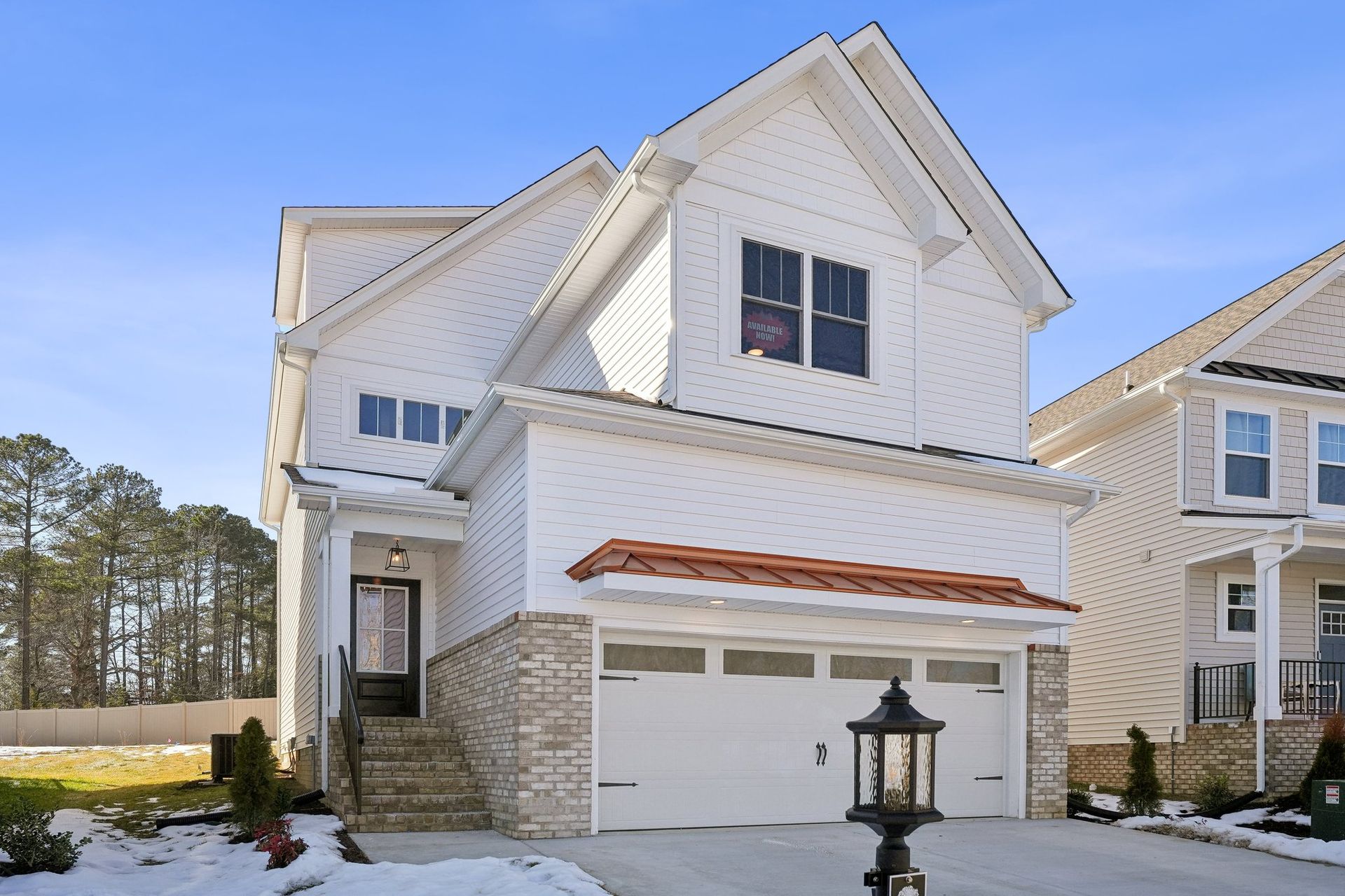 A white house with a large garage and a lantern in front of it