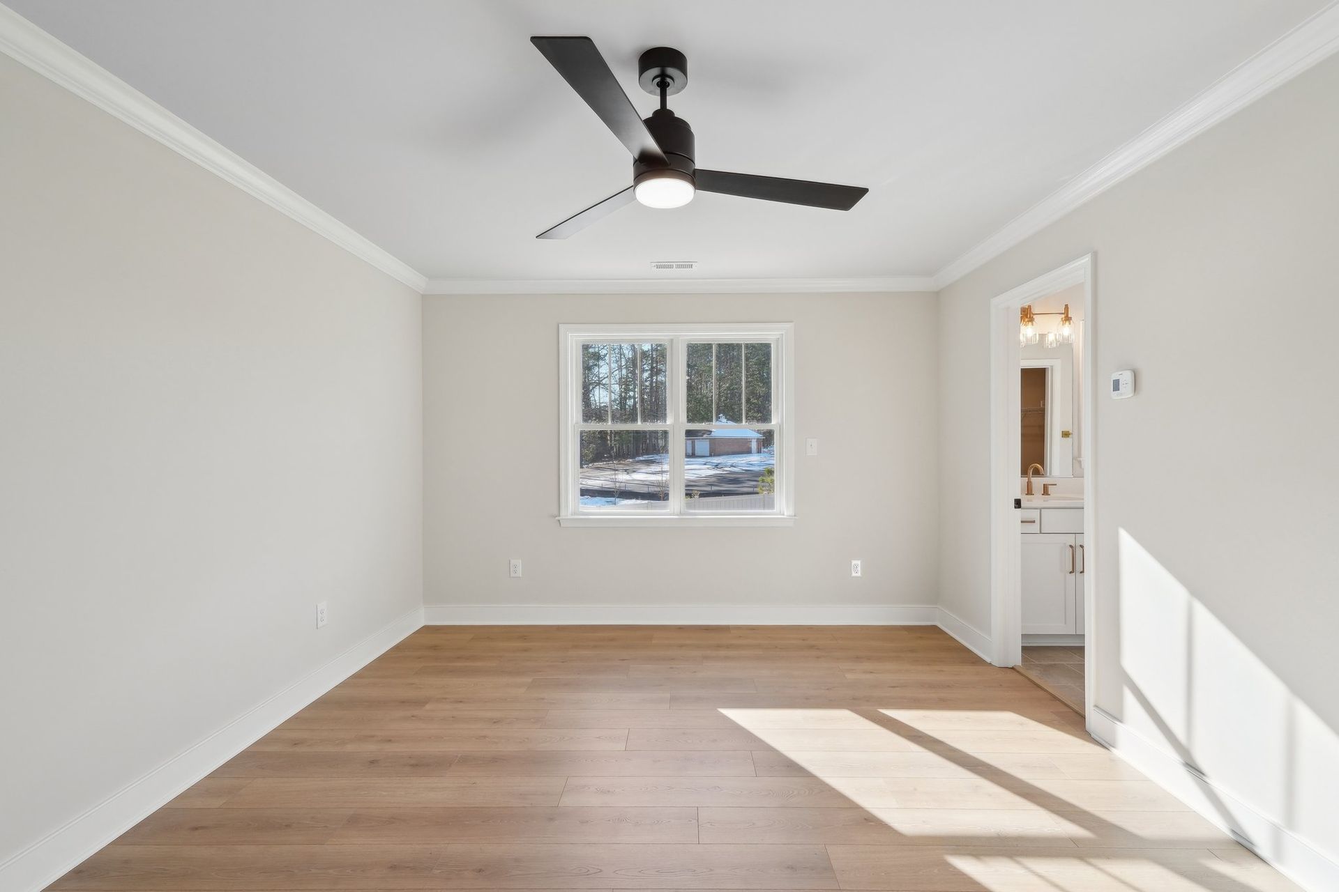 An empty room with a ceiling fan and a window