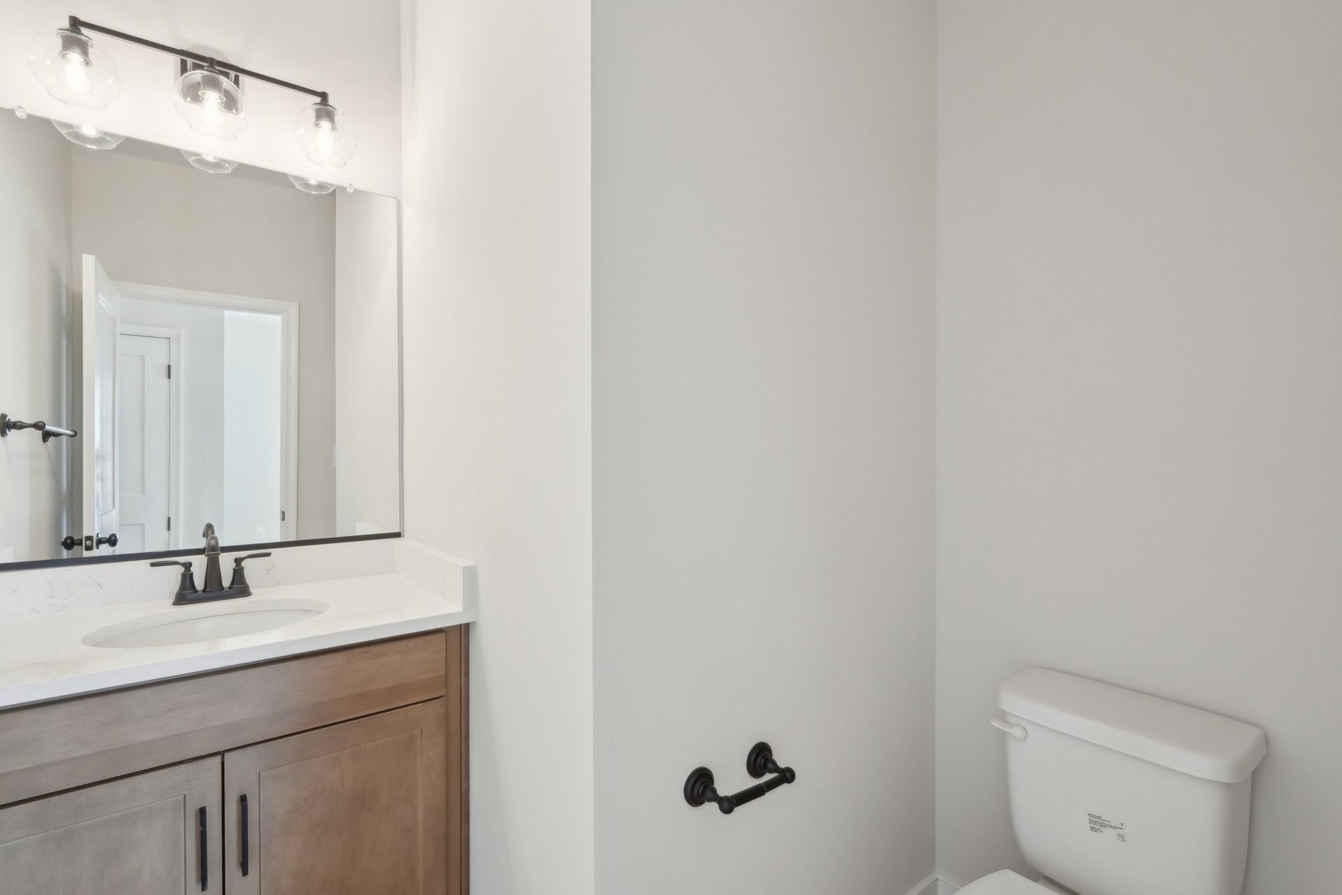 A bathroom with a sink , toilet and mirror.