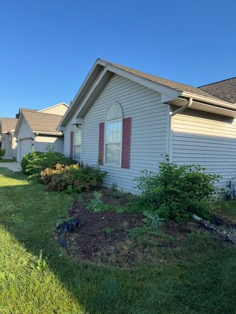 Workers in orange jackets shovel snow from a park walkway.