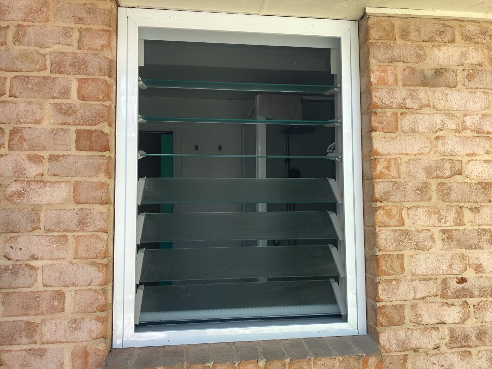 A Window with Shutters on It Is on A Brick Wall — Boambee Gauze 'n' Glass in Harbour, NSW