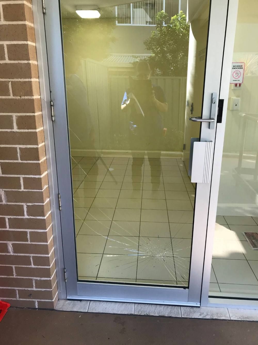 A Door with A Reflection of A Person in It — Boambee Gauze 'n' Glass in Harbour, NSW