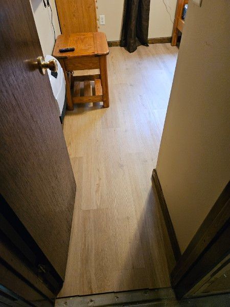 Doorway to a room with light wood-look flooring. A small wooden chair sits inside.