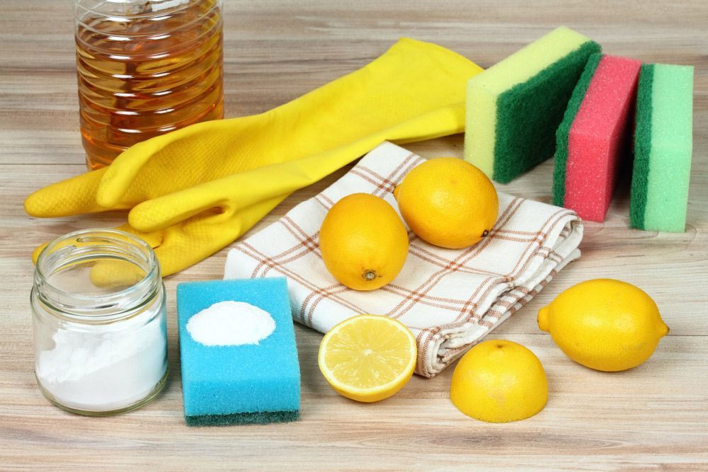 A Wooden Table Topped With Lemons , Sponges , Baking Soda , And Gloves — AGB Cleaning In Bentley Park, QLD