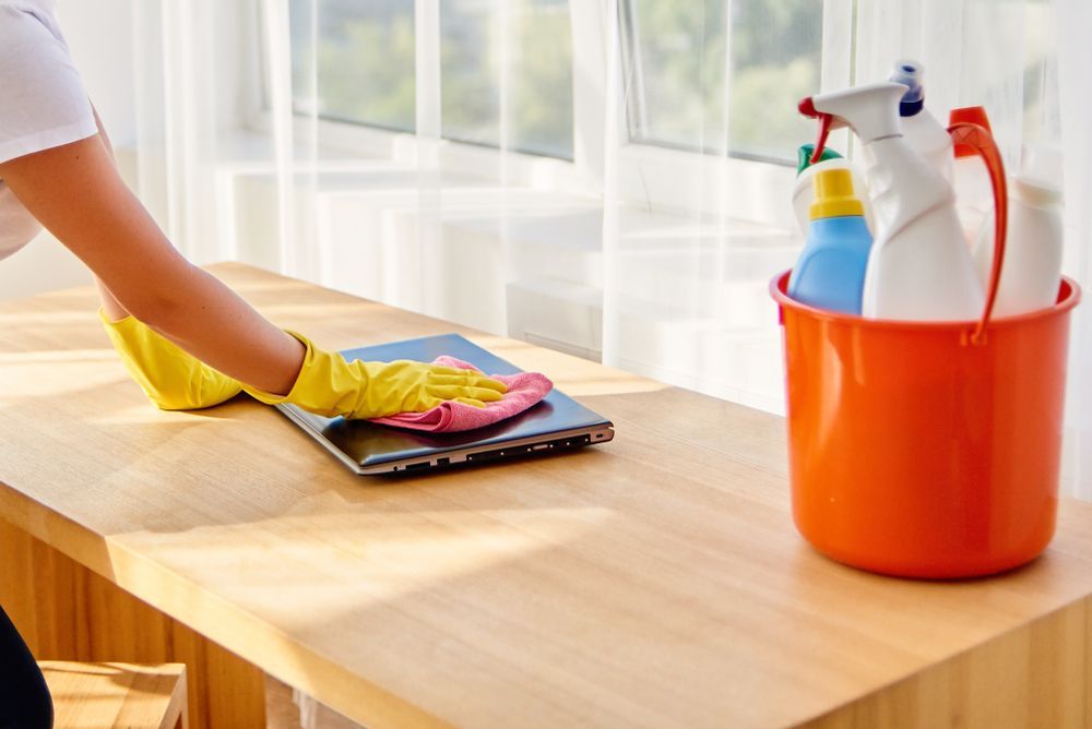 A Person Wearing Blue Gloves Is Picking Up Plastic Bottles From A Trash Bag — AGB Cleaning In Bentley Park, QLD