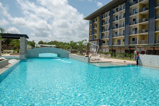 A Large Swimming Pool With a Fountain in Front of a Building  — Figleaf Pool Products in Coconut Grove, NT