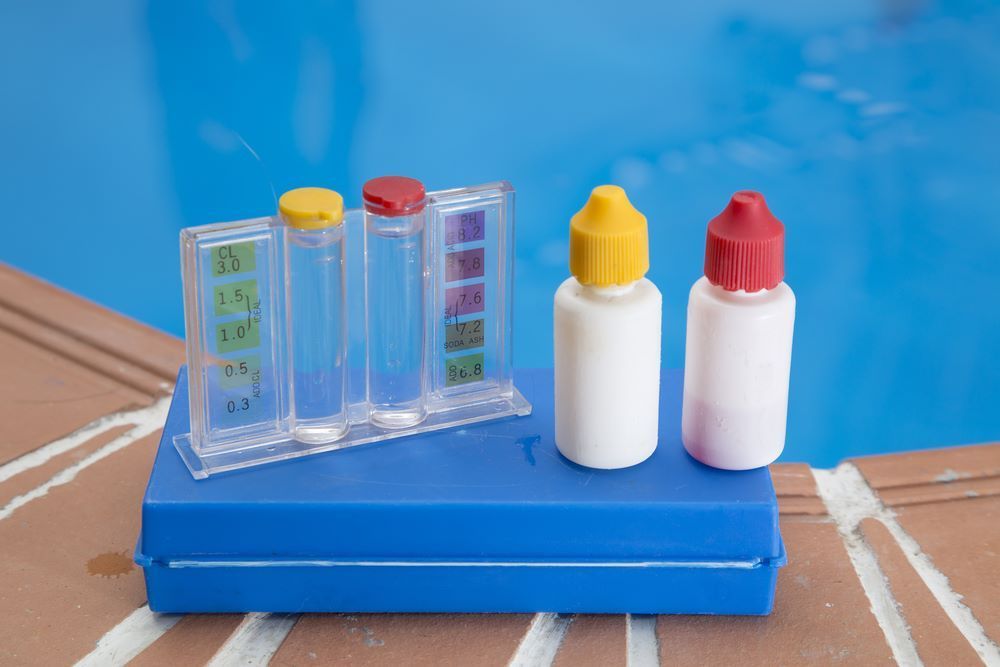 Three Bottles of Chemicals Are Sitting on Top of a Blue Box — Figleaf Pool Products in Casuarina, NT