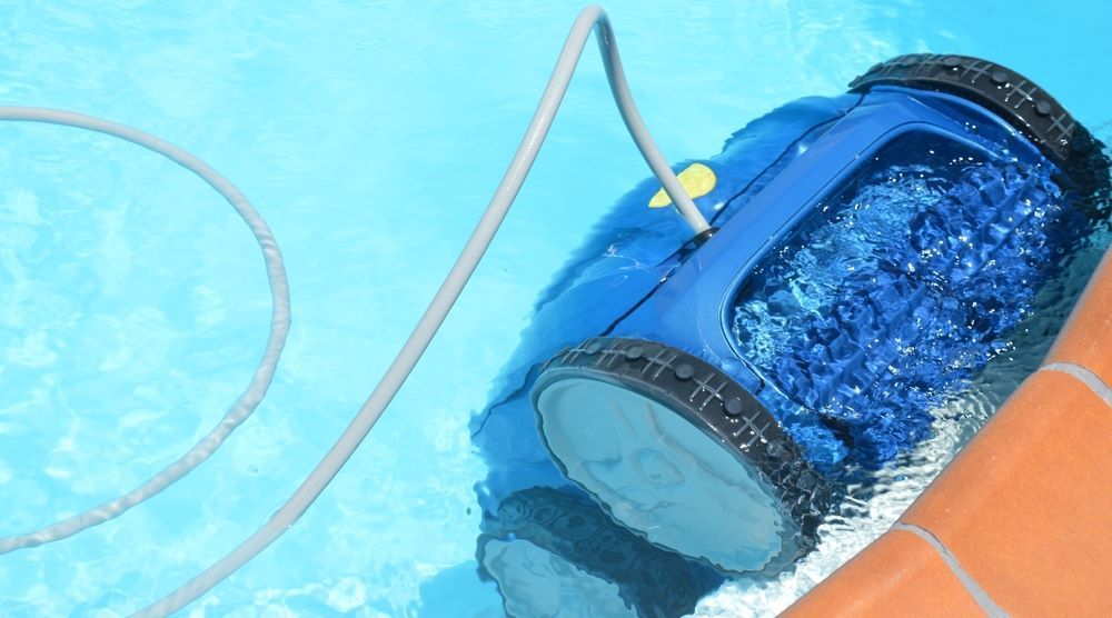 A Blue Robotic Vacuum Cleaner is Cleaning a Swimming Pool — Figleaf Pool Products in Coolalinga , NT