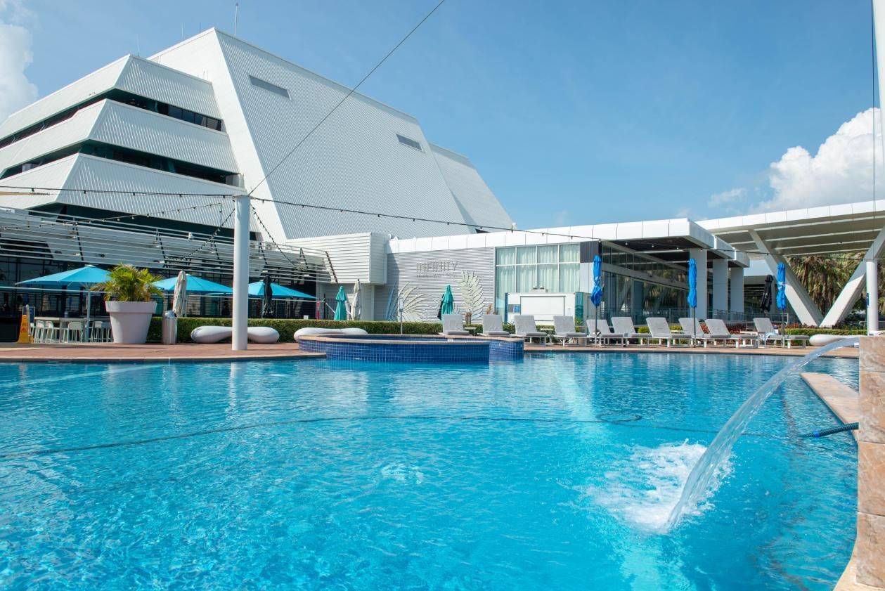 A Large Swimming Pool with A Fountain in Front of A Building — Figleaf Pool Products in Coconut Grove, NT