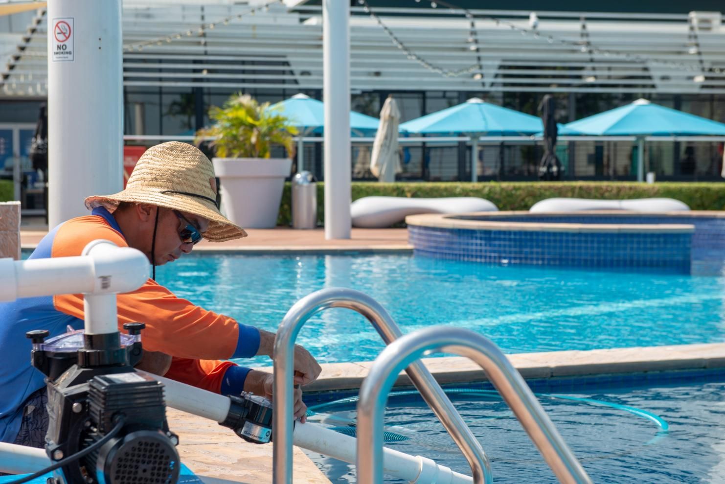 A Man in A Straw Hat Is Working on A Swimming Pool — Figleaf Pool Products in Coconut Grove, NT