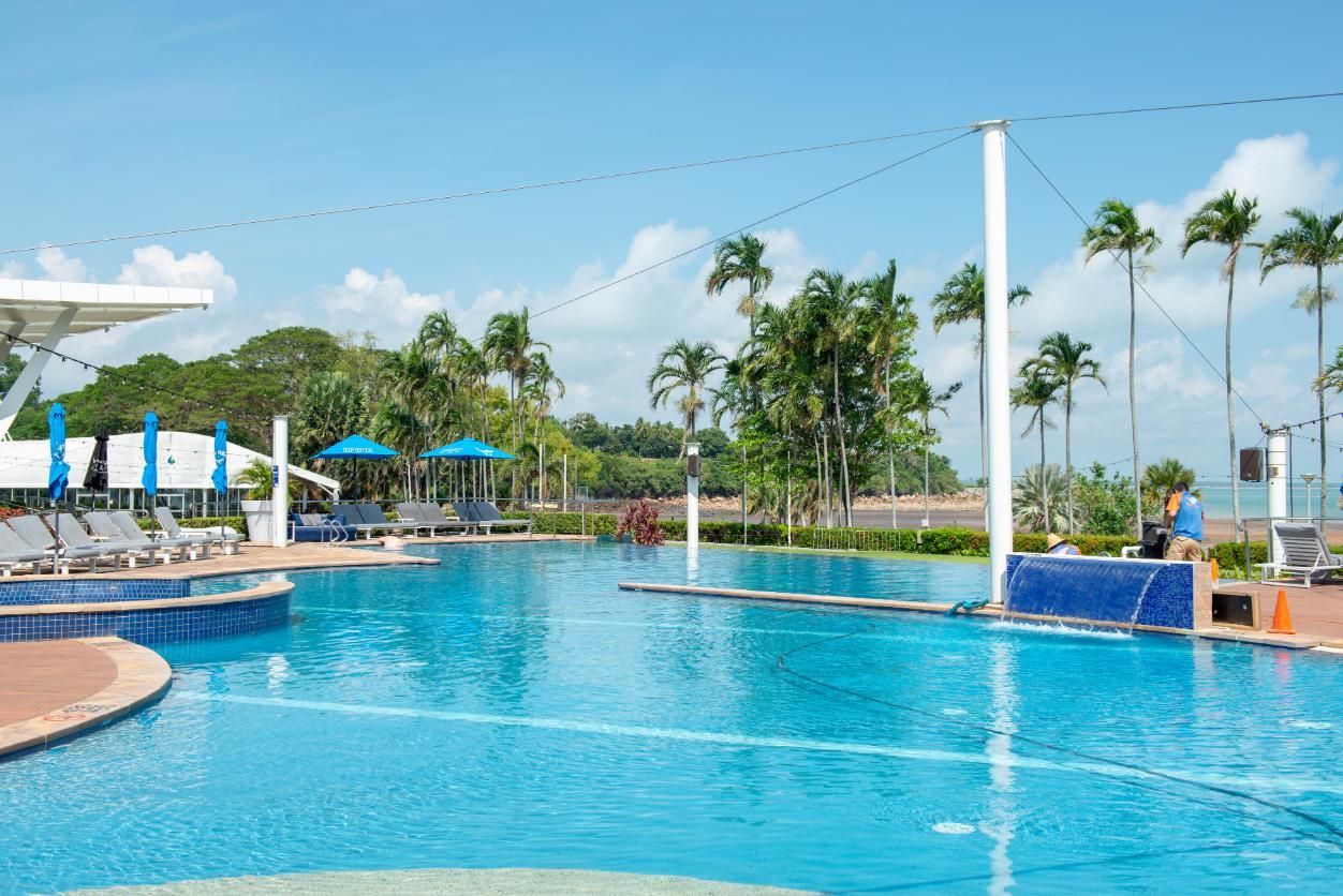 A Large Swimming Pool with Palm Trees in The Background — Figleaf Pool Products in Coconut Grove, NT