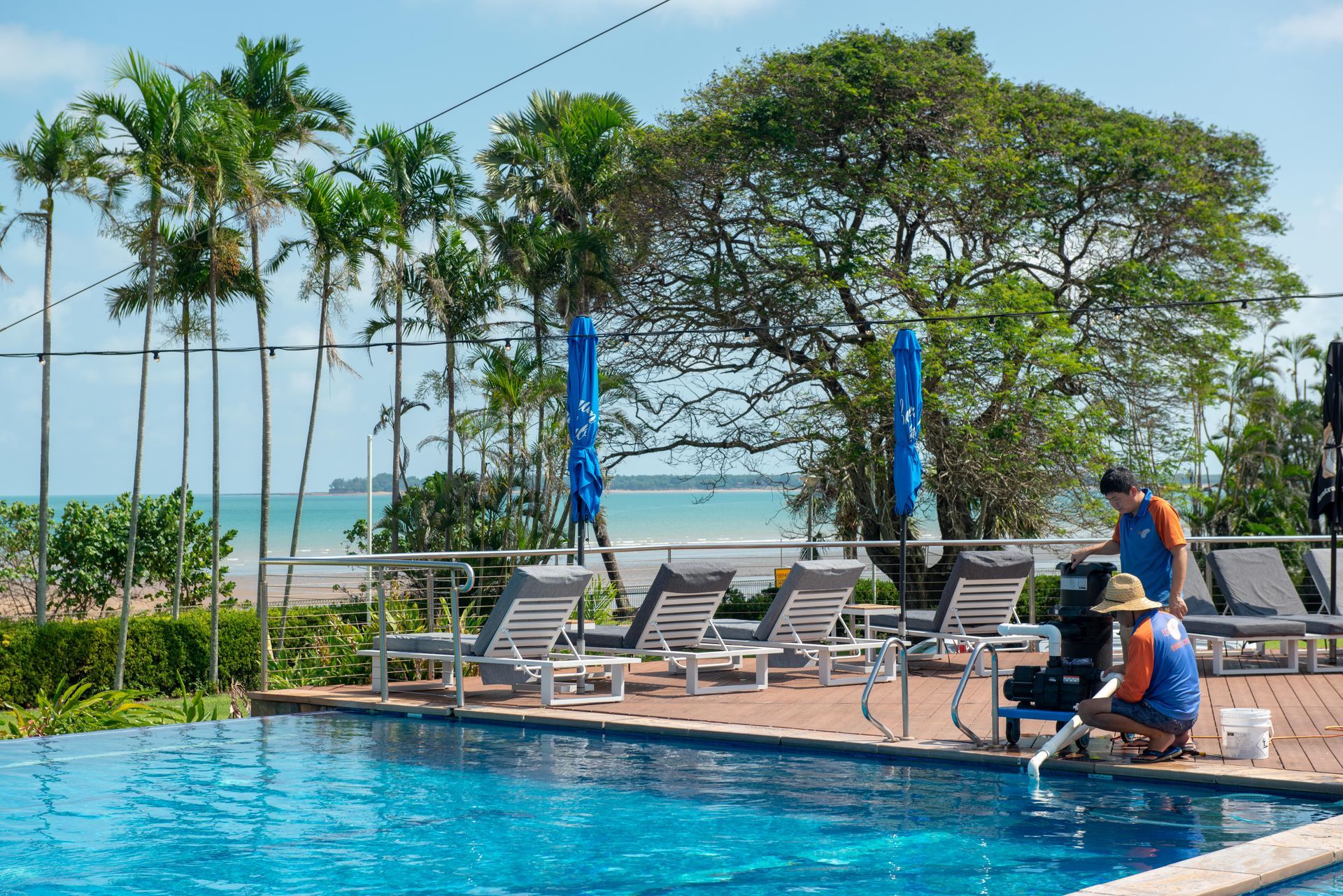 Two Men Using a Water Pump to Clean a Pool  — Figleaf Pool Products in Coconut Grove, NT