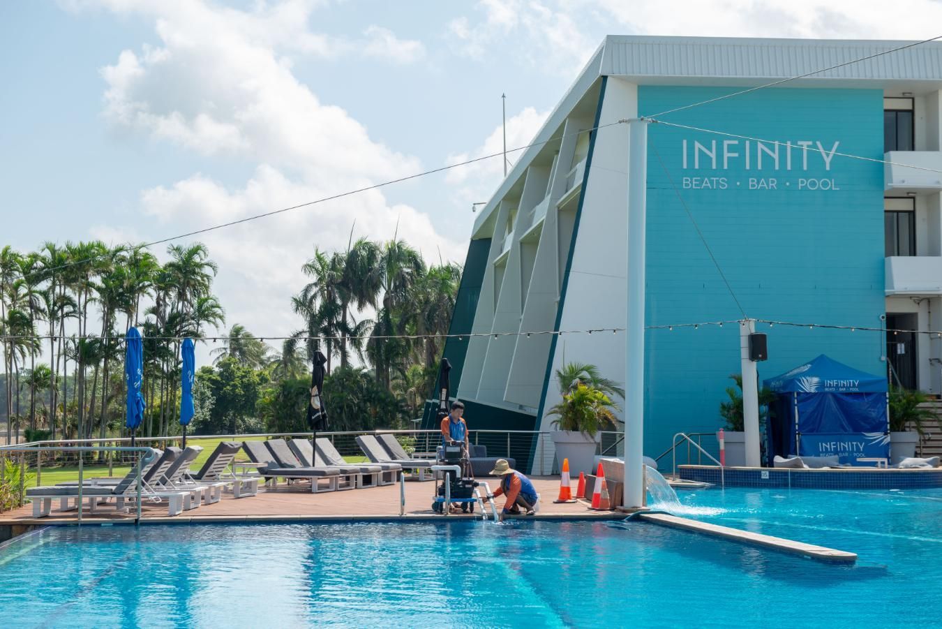 A Large Swimming Pool in Front of A Building that Says Infinity — Figleaf Pool Products in Coconut Grove, NT
