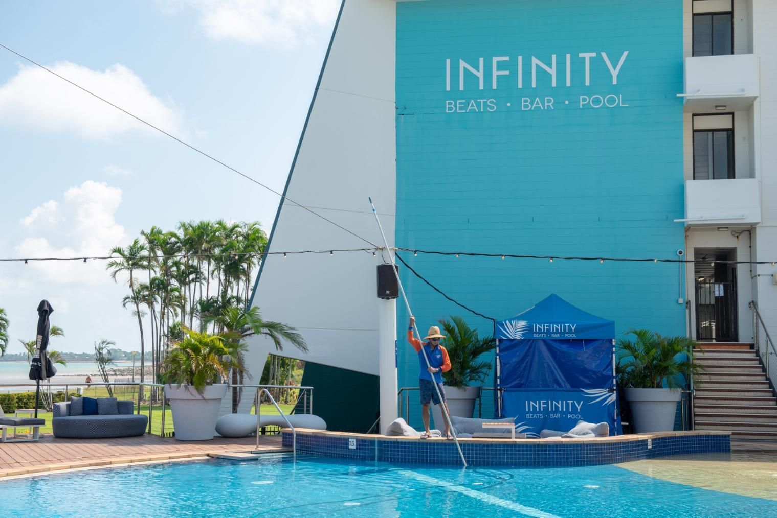 A Swimming Pool in Front of A Building that Says Infinity — Figleaf Pool Products in Coconut Grove, NT