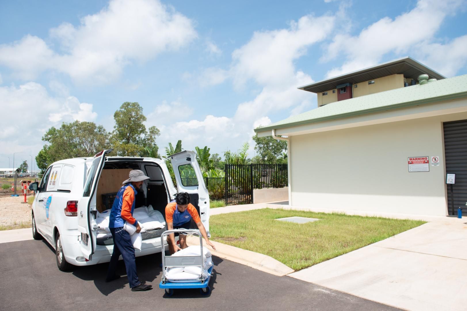 Two Men Are Pushing a Cart Next to A Van — Figleaf Pool Products in Coconut Grove, NT