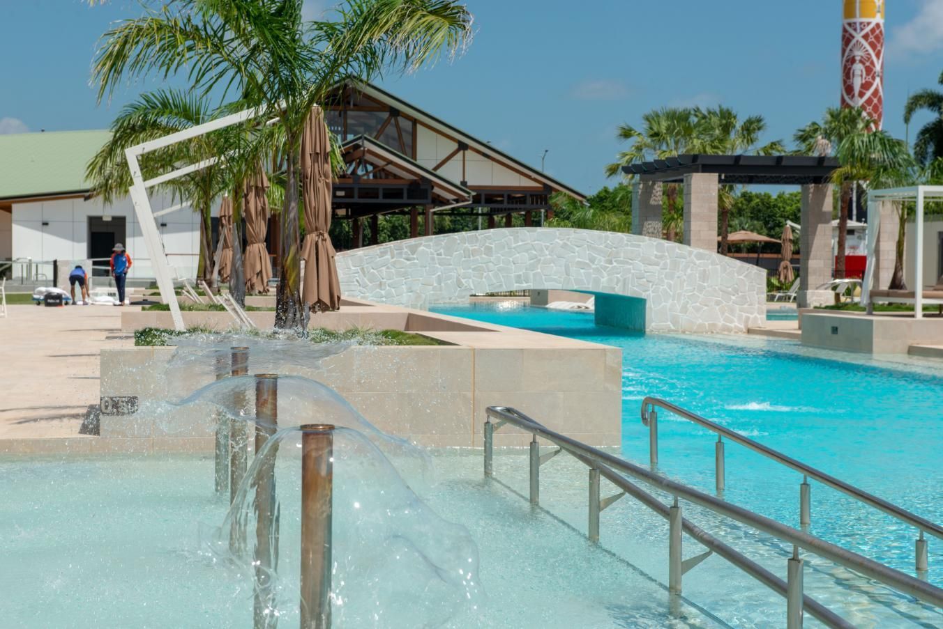 A Swimming Pool with A Ramp and A Fountain in Front of A Building — Figleaf Pool Products in Coconut Grove, NT